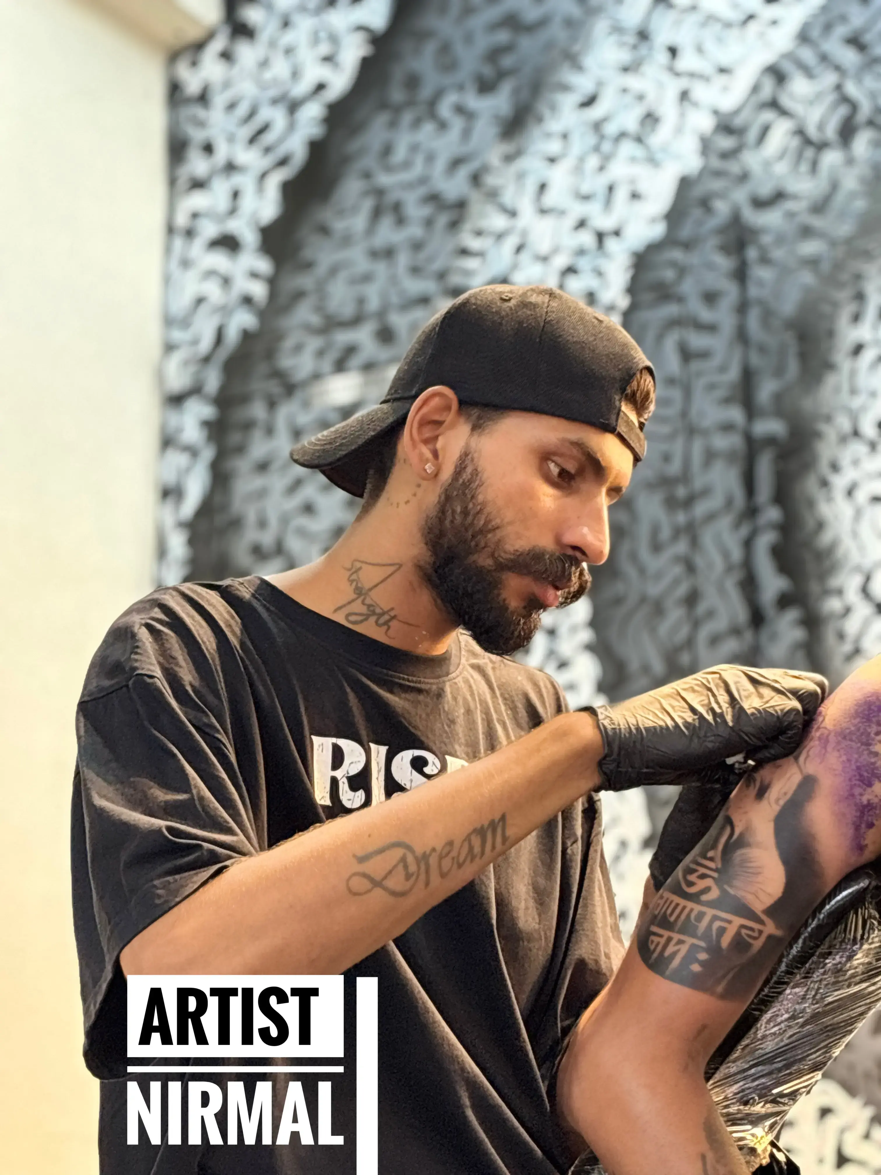 Artist Nirmal creating a custom tattoo in Udaipur